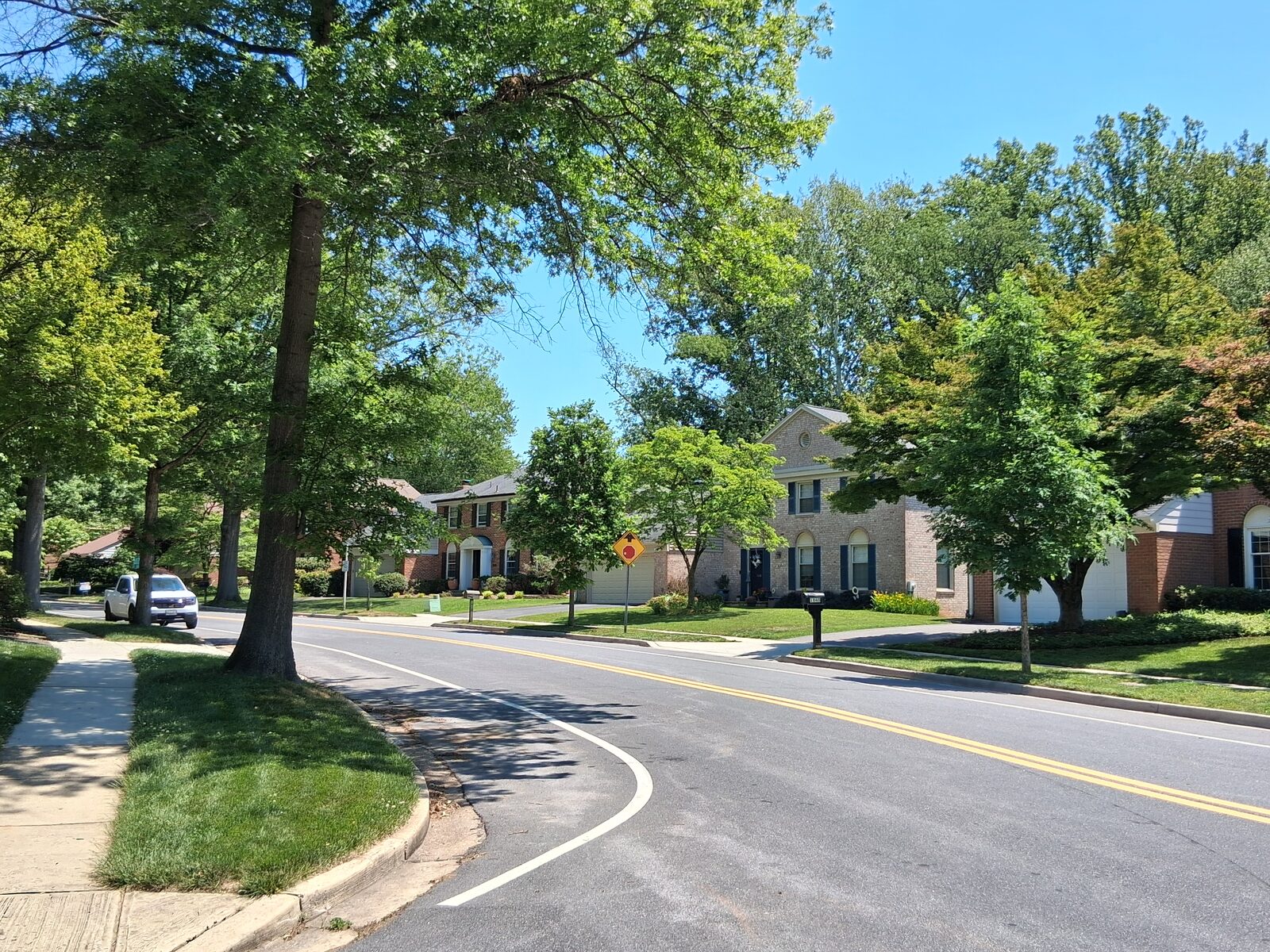 Curving, tree-lined Greenplace Terrace with colonial homes in Fallsmead, Rockville