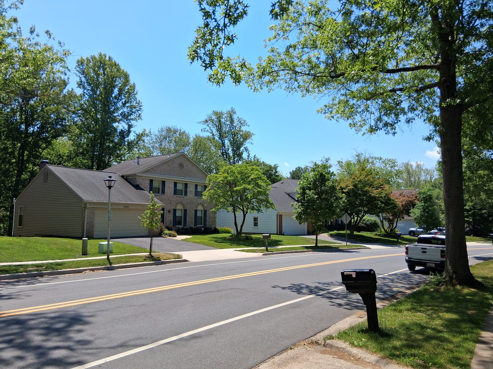 Curving tree-lined street with a mailbox in Fallsmead, Rockville